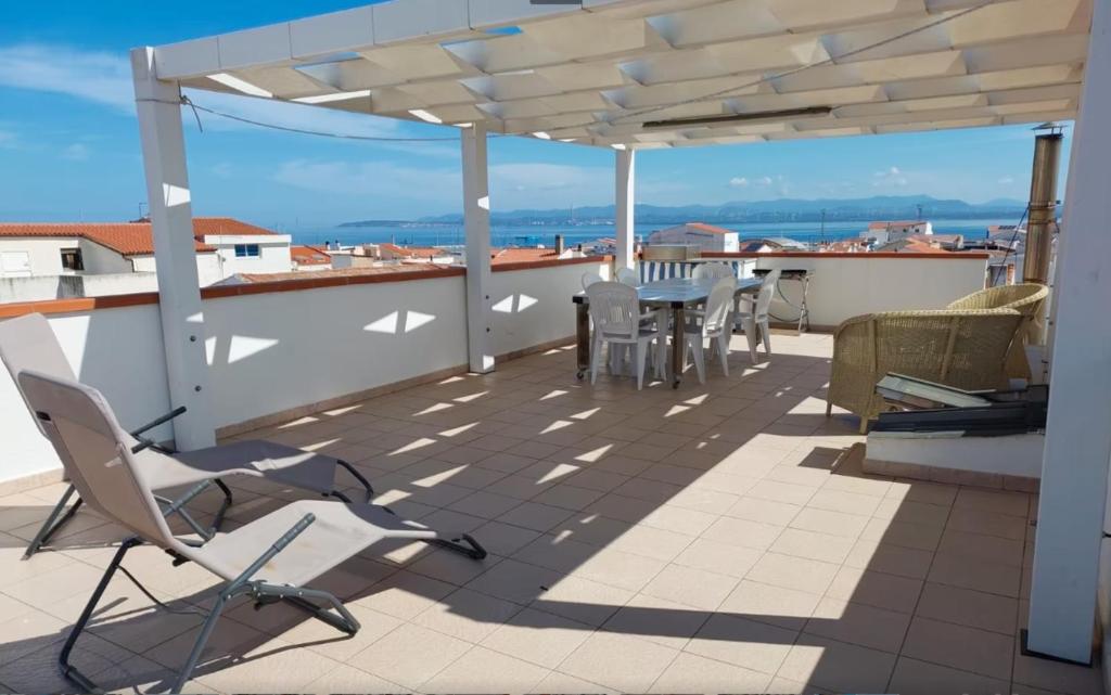 Un patio con sillas y una mesa en un tejado. en Casa Susanna, en Calasetta