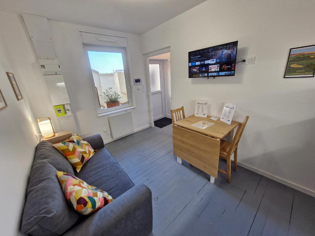 a living room with a couch and a table at Appartement F2 5A in Martres-de-Veyre