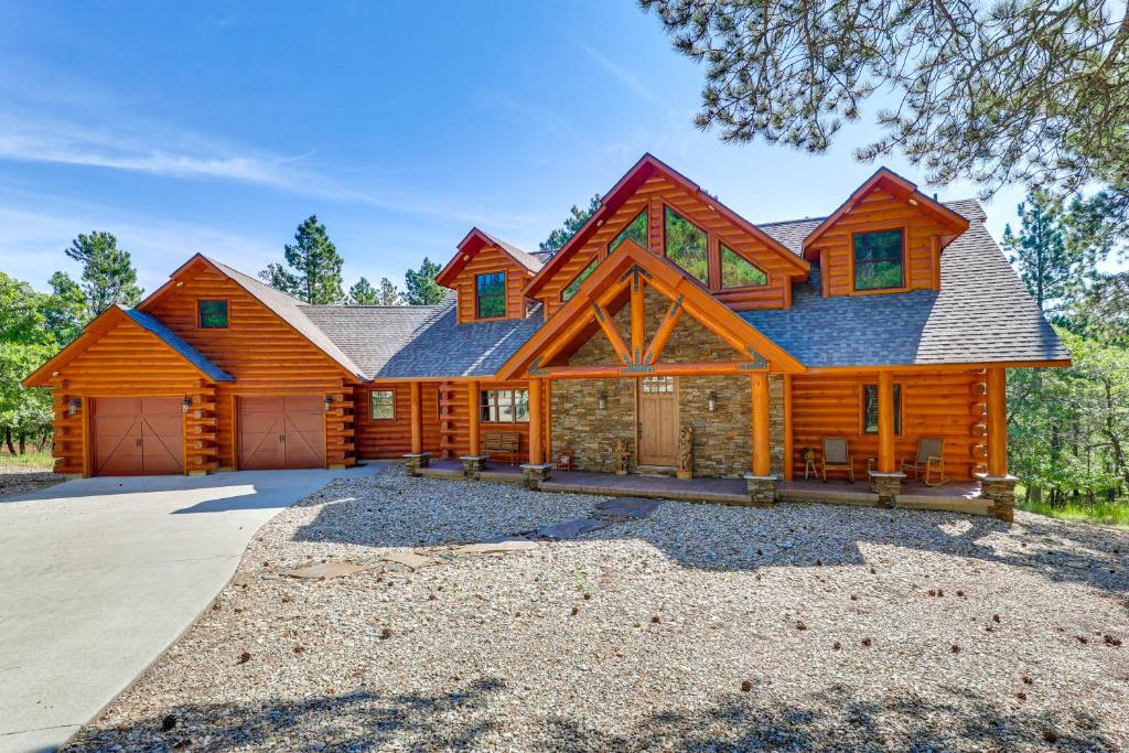 a large log cabin with a gambrel roof at Hike, Fish and More Grand Cabin with Decks in Sturgis in Crook City