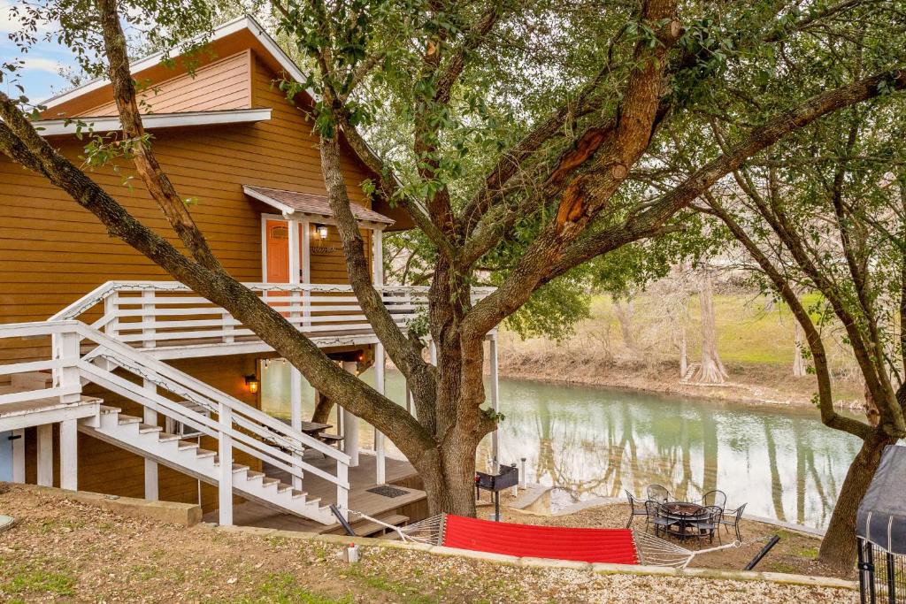 a house with a deck next to a lake at Earth Haus LITE in Fourth Crossing
