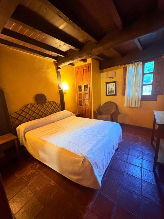 a bedroom with a white bed in a room at Apartamentos Rurales La Plaza in Cabezuela del Valle