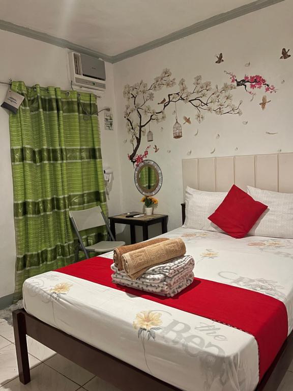 a bedroom with a bed with a red and white blanket at YOO Darius' Residences in Moalboal