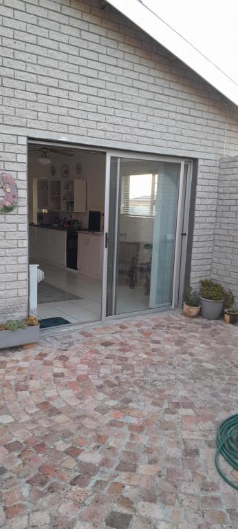 an open sliding glass door of a house at Our Little House in Franskraal