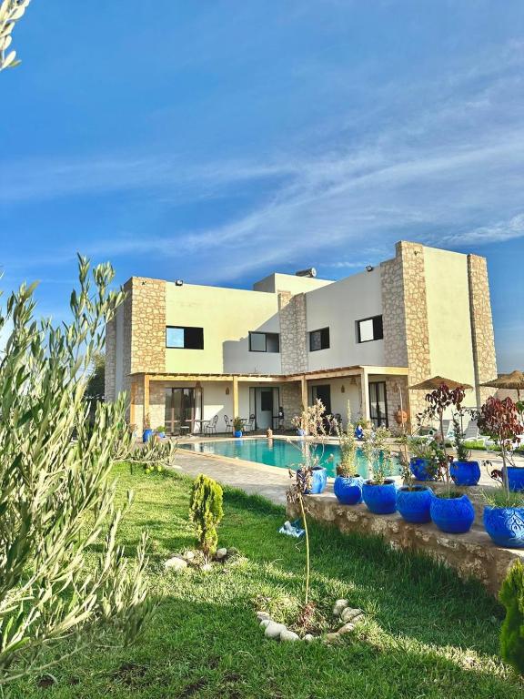 a large building with a swimming pool and blue bowls at Chambre Agadir in Essaouira
