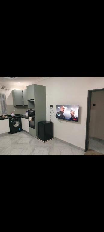 Una sala de estar con un televisor en la pared. en Silver villa, en Lusaka