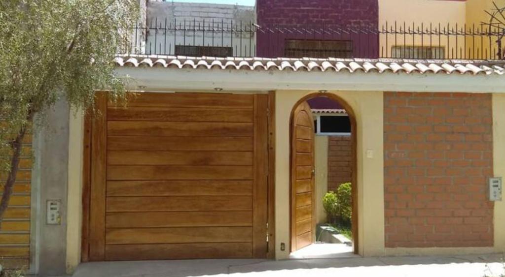a wooden garage door with an arch in a house at casa alameda Miraflores in Miraflores