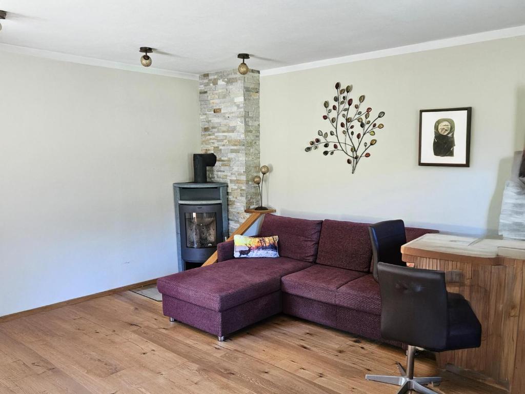 a living room with a purple couch and a fireplace at Haus Johanna in Wenns