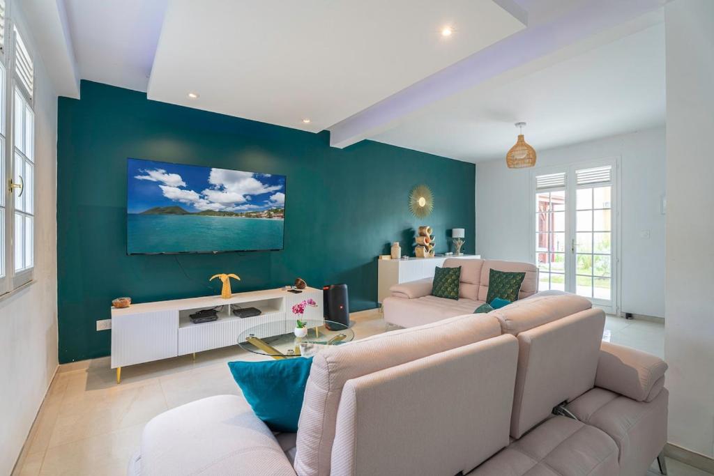 a living room with a couch and a table at Villa Rose Du Désert in Sainte-Anne