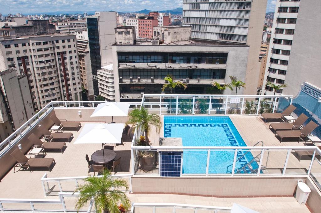 un balcón con piscina en la azotea de un edificio en Normandy Hotel, en Belo Horizonte
