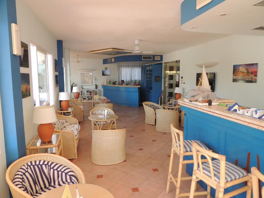 a restaurant with chairs and tables and a bar at Hotel Viticcio in Portoferraio