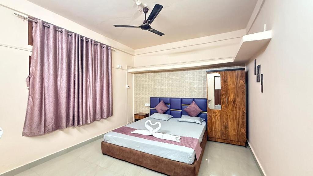a bedroom with a bed with a purple headboard at Royal Palace in Dibrugarh