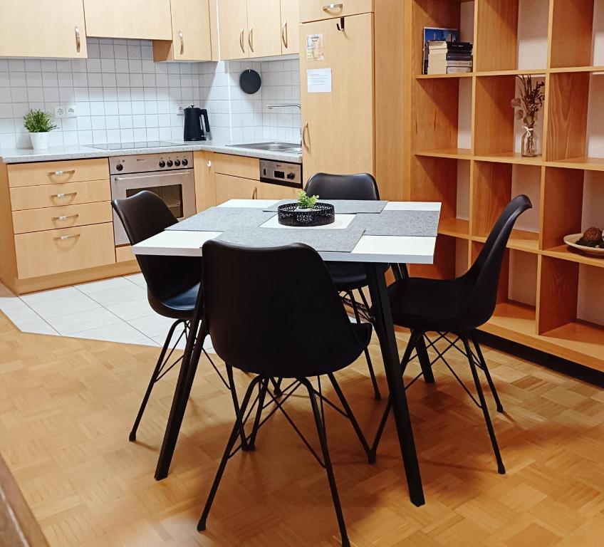 a kitchen with a table and black chairs at TauberNest in Bad Mergentheim