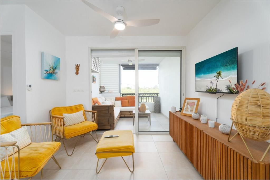 ein Wohnzimmer mit gelben Stühlen und einer Couch in der Unterkunft Appartement Hibiscus Bay in Fort-de-France
