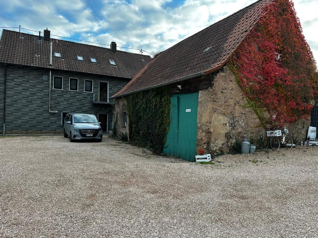 a car parked next to a building with a green door at Hof Quartier 6 in Neunkirchen