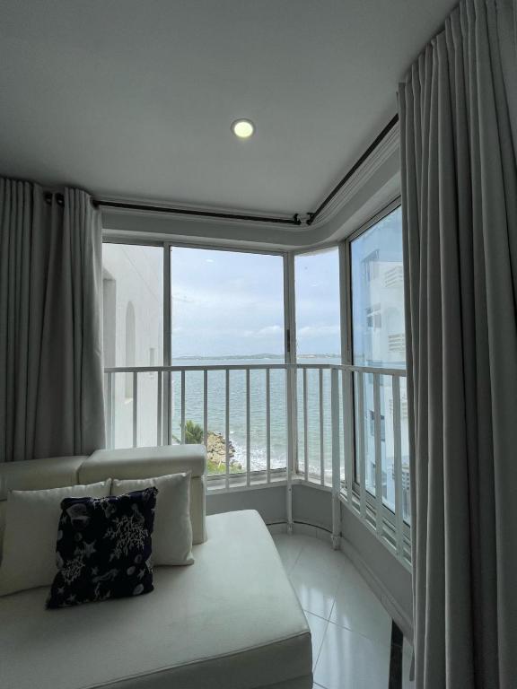 a living room with a couch and a large window at Loft in Cartagena with direct beach access in Cartagena de Indias