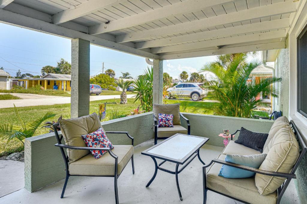 un porche con sillas, una mesa y un coche en Ormond Beach Family Home Between River and Ocean, en Ormond-by-the-Sea