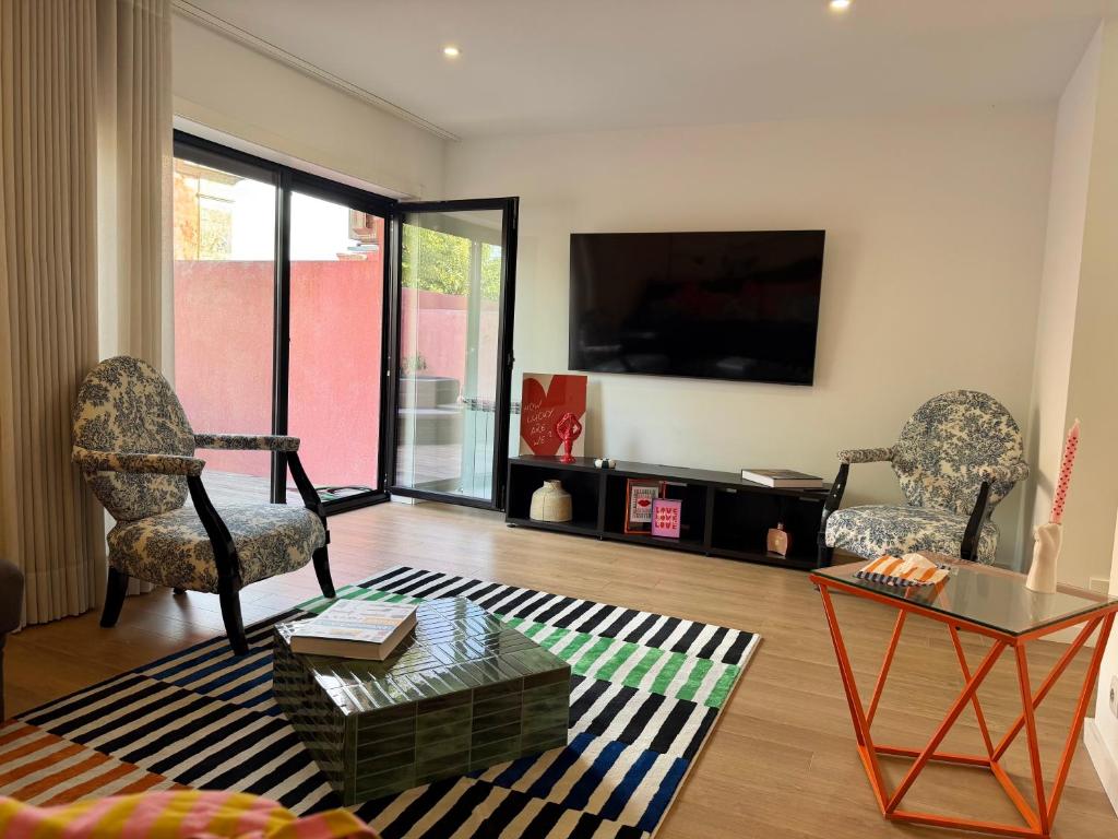 a living room with two chairs and a tv at Casa Brasão - Celorico de Basto in Celorico de Basto