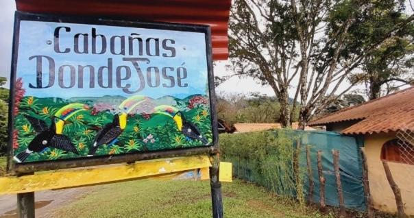 a sign in front of a house with a sign for a gardendoodleoss at Cabañas DondeJosé in Valle de Anton