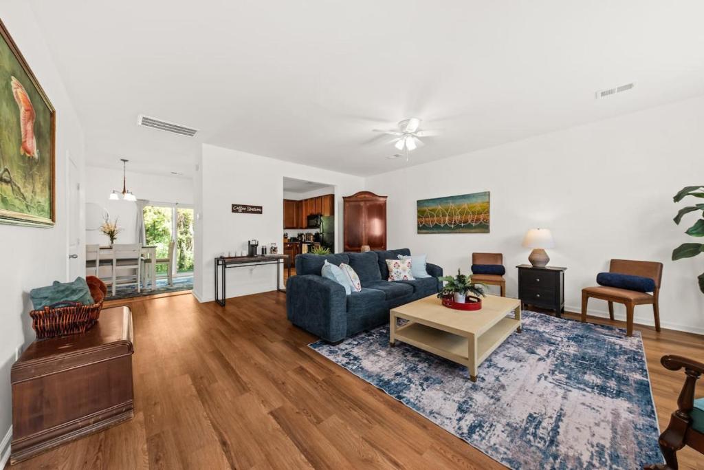 a living room with a blue couch and a table at Southern Oak Cottage in Ladson