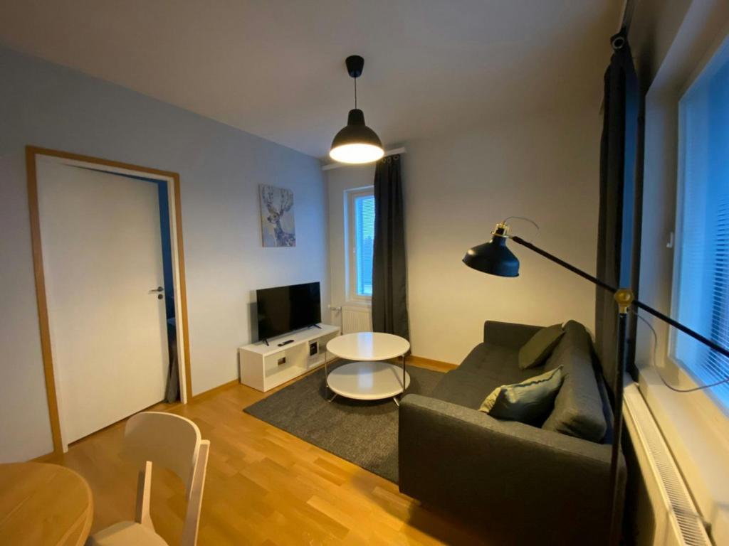 a living room with a couch and a table at Modern Apartment for 3 with Sauna in Kemi