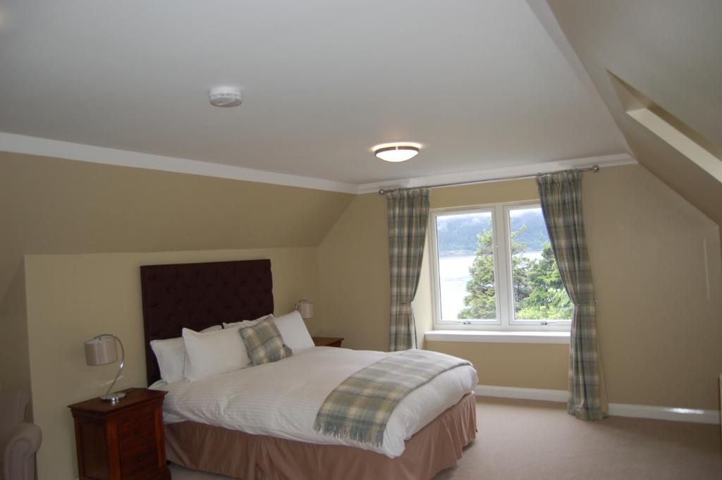 um quarto com uma cama e uma janela em Allt Nan Ros Apartments fort william em Onich