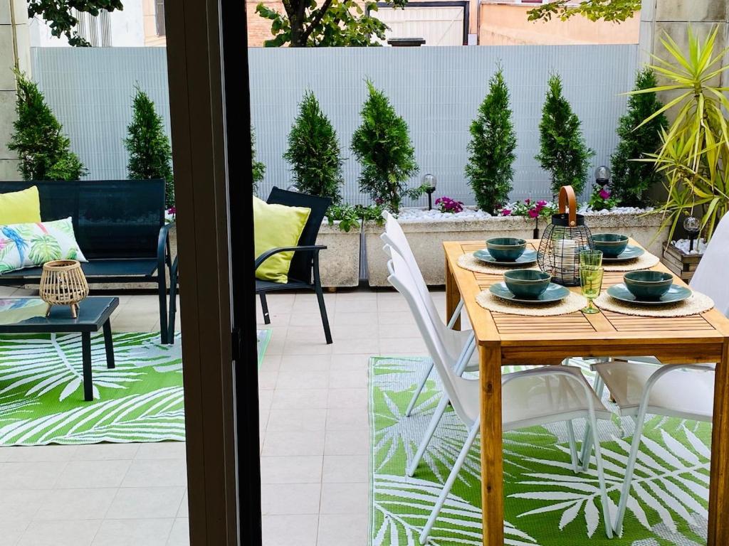 a wooden table and chairs on a patio at Spacious, cozy apartment with garden in Logroño