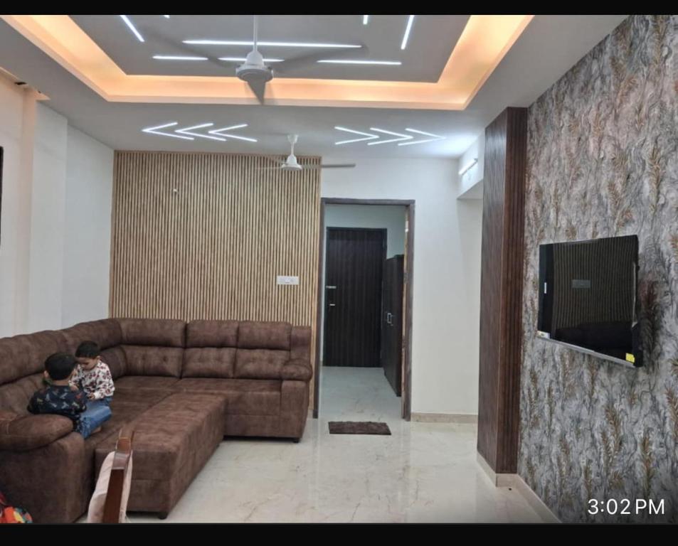 two children sitting on a couch in a living room at YR Heights Home Stay in Hyderabad