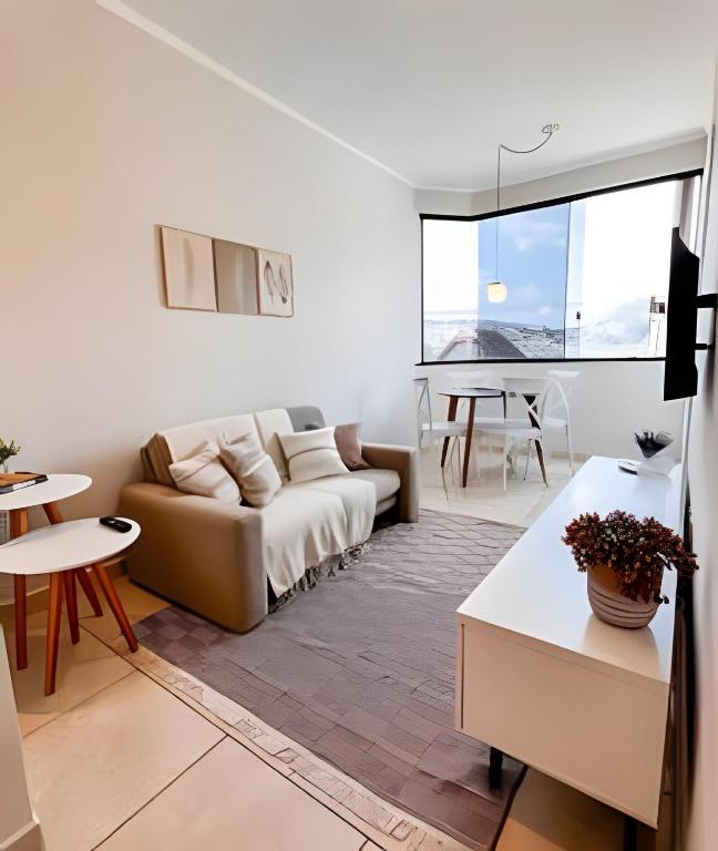 a living room with a couch and a table at Ap 101 - Apartamento no centro da cidade in Maria da Fé