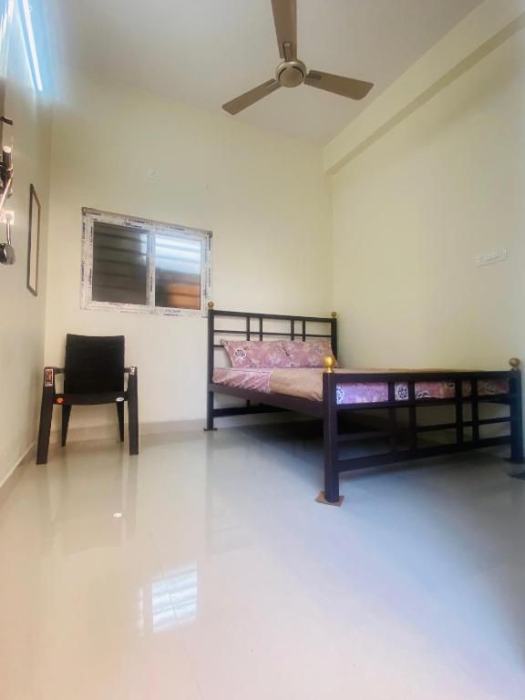 a bedroom with a bed and a chair in it at Sree Sripadha Bhavan in Pithāpuram