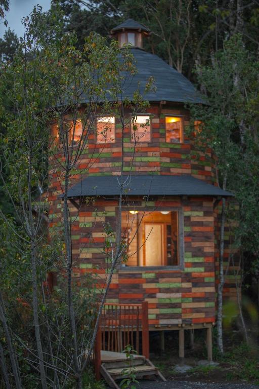 a log cabin in the woods with a roof at Aremko Aguas Calientes & Spa in Puerto Varas
