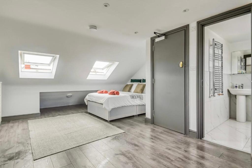a bedroom with a bed and a bathroom with skylights at The Little Oaks House in Birmingham