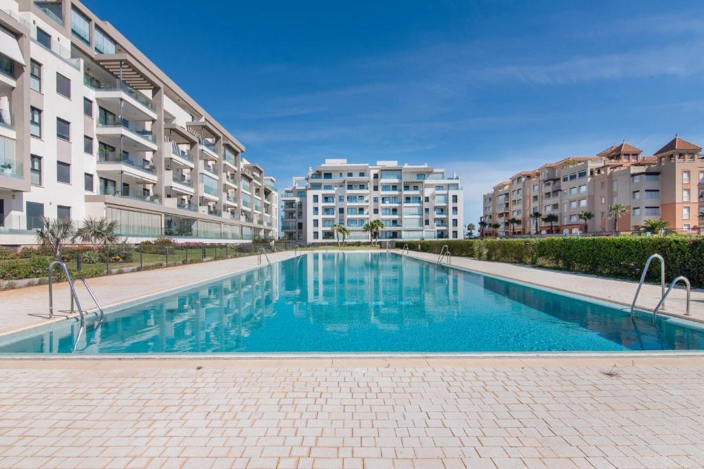 una piscina en un complejo de apartamentos con edificios en Los Flamencos, en Isla Canela