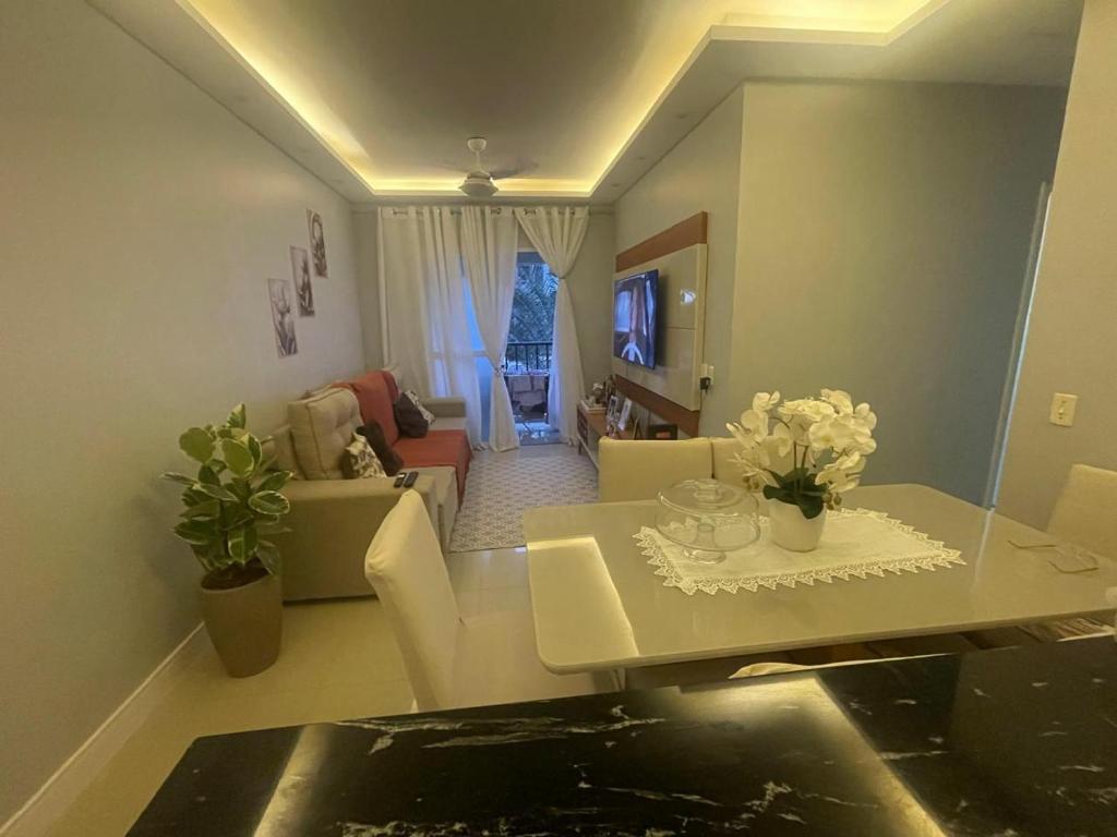 a living room with a table and a living room at Apartamento em condomínio in Ananindeua