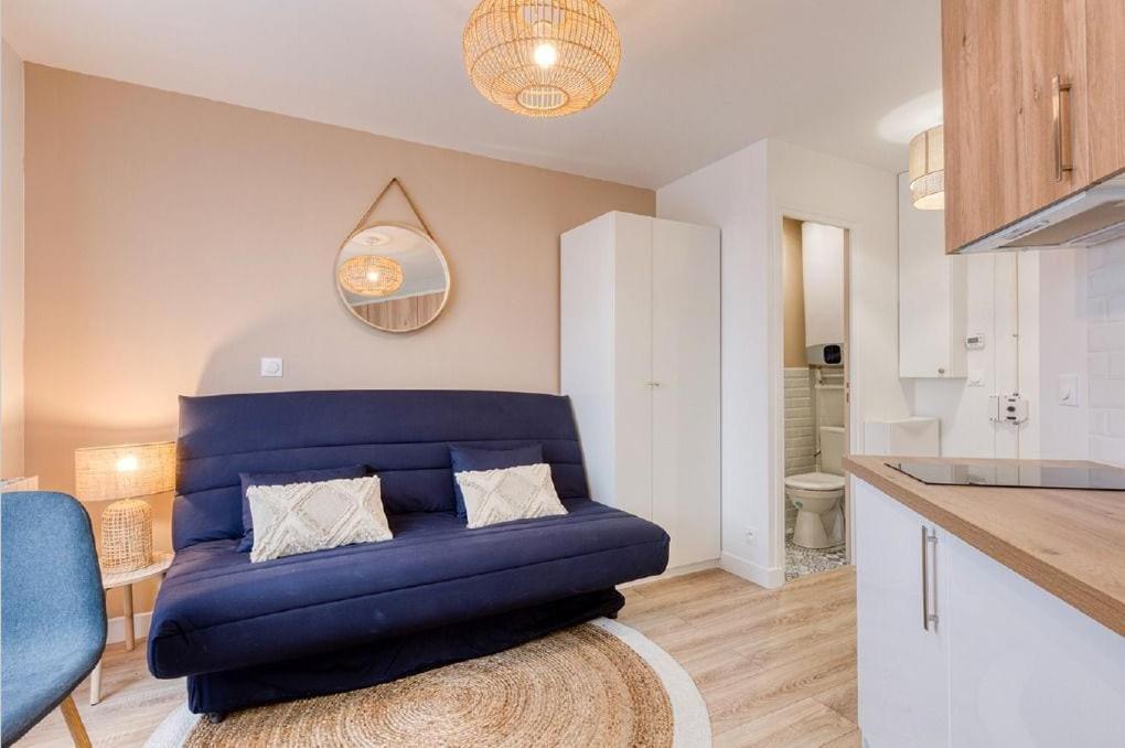 a living room with a blue couch in a kitchen at Great Cozy Studio - Paris in Bagnolet