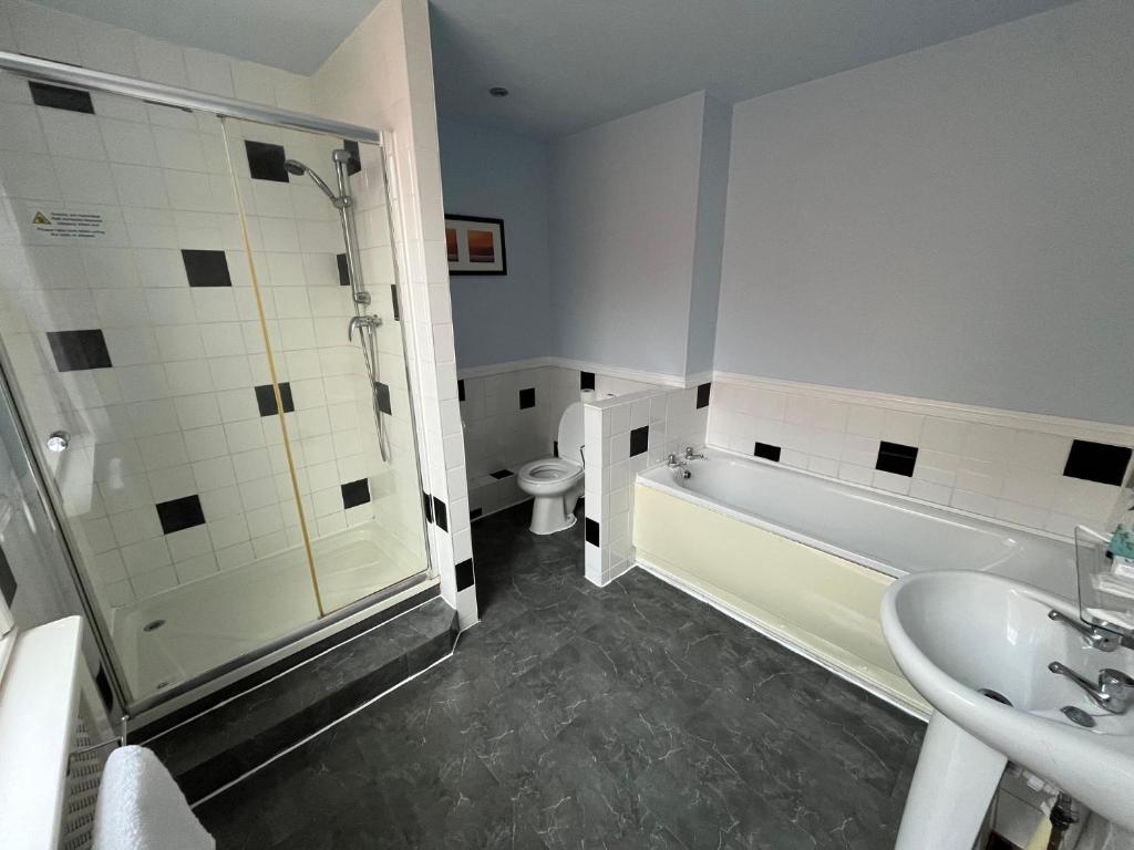 a bathroom with a shower and a toilet and a sink at Castle Hotel Tamworth in Tamworth