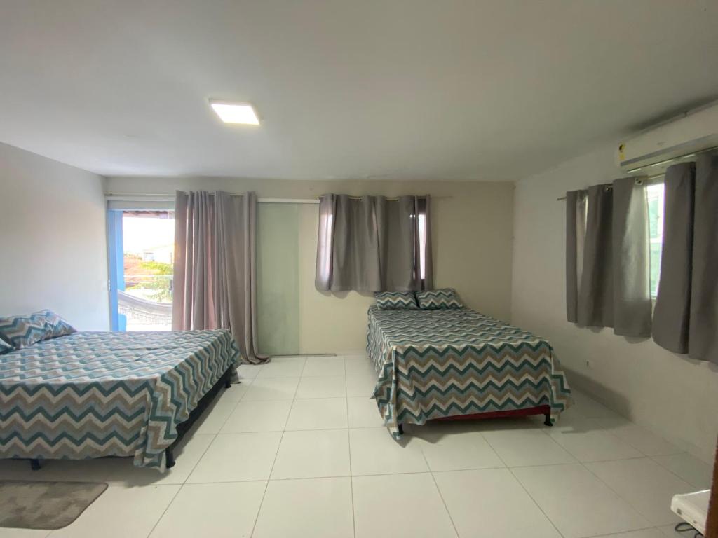 Una habitación de hotel con dos camas y una ventana. en Siqueira Beach house, en Tamandaré