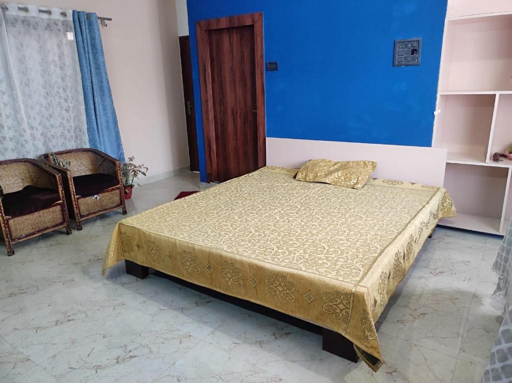 een slaapkamer met een bed en een blauwe muur bij GoFam in Dibrugarh