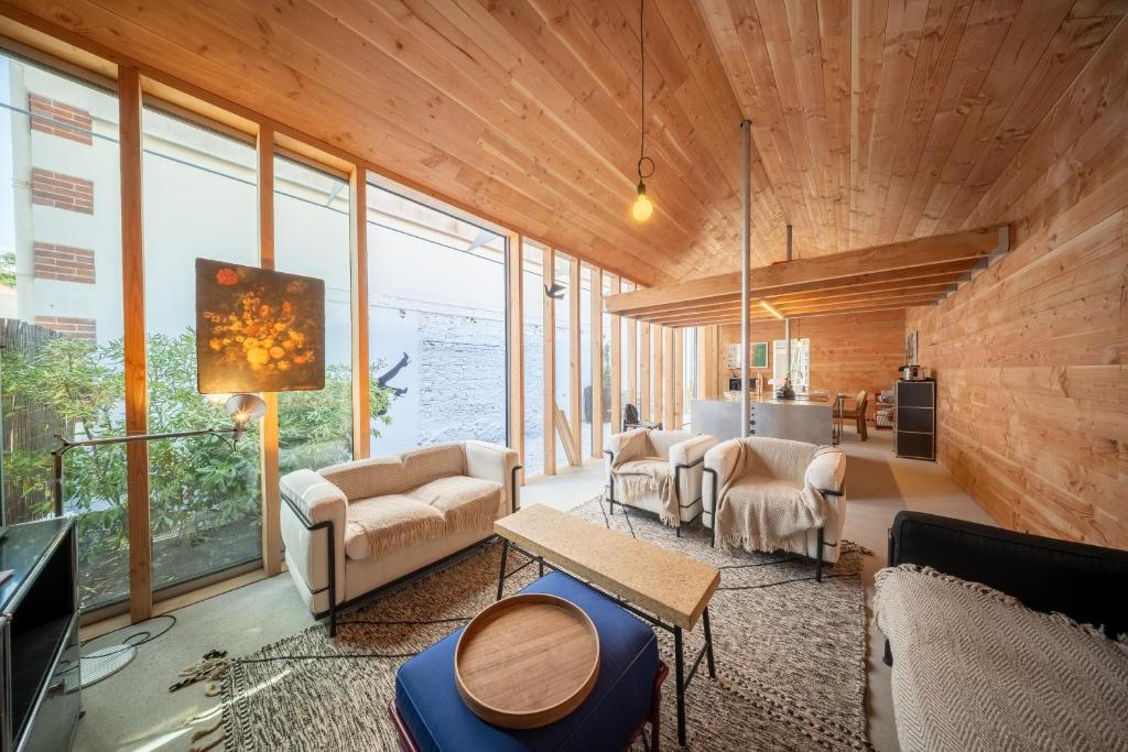 una sala de estar con paredes de madera y ventanas grandes. en Cala Cabin - Heart of Arcachon & beaches on foot!, en Arcachon