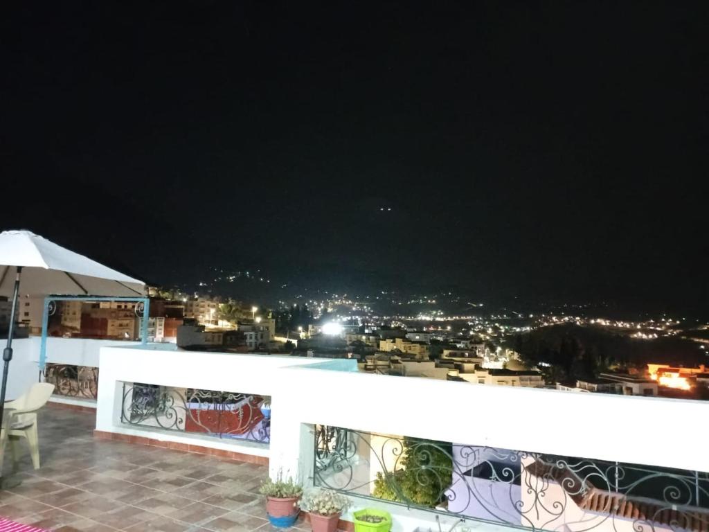 a view of the city from a balcony at night at Dar Boukhari Luxury Stay in Chefchaouene