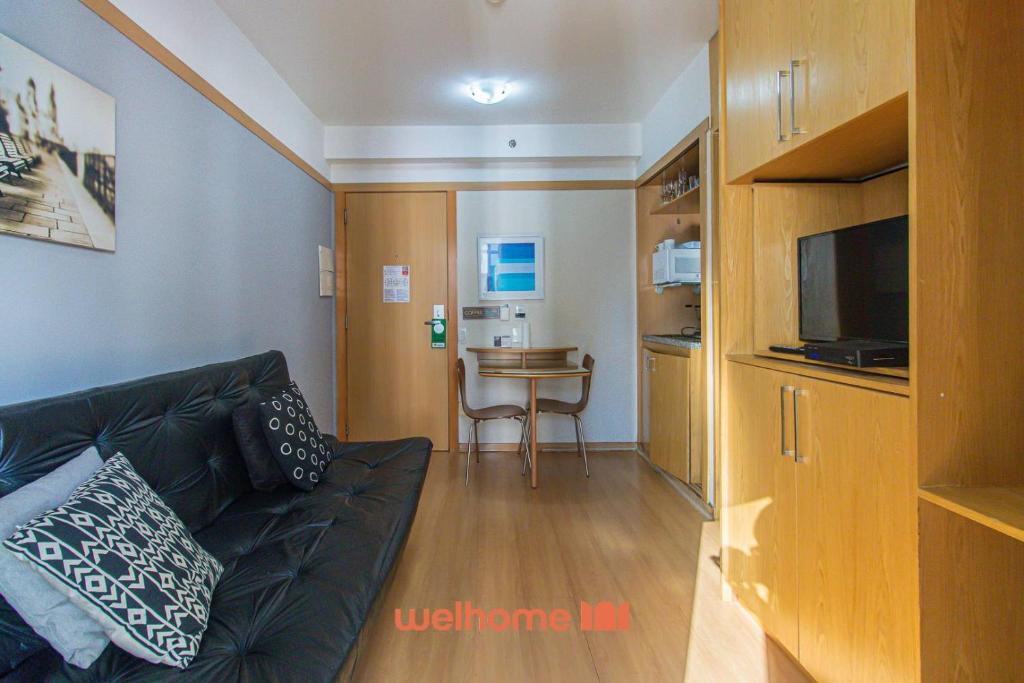 a living room with a couch and a television at Flat na Bela Cintra duas quadras da Av Paulista in Sao Paulo