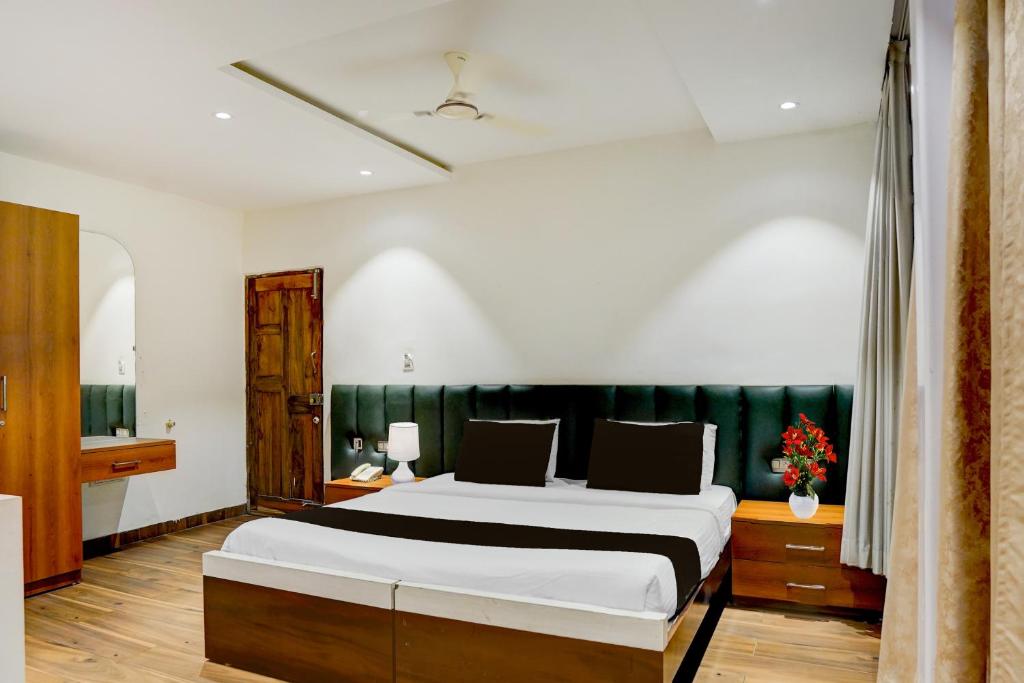 シモガにあるTownhouse Shivamogga Railway Junction Formerly Amma Residencyの緑のヘッドボードが付いた大きなベッドのある寝室