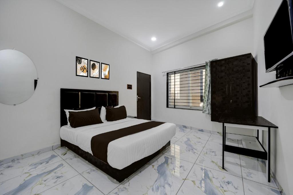 a white bedroom with a bed and a window at Hotel O Choice Inn II in Rao