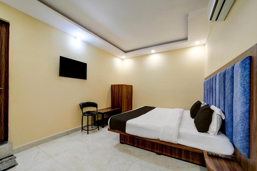 HabībganjにあるHotel O Balaji Palaceのベッドと壁にテレビが掛かった寝室