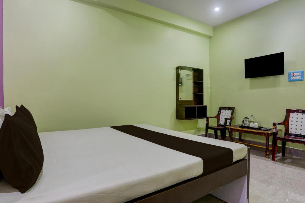 a bedroom with a bed and a table and a television at Hotel O SAI KRISHNA GUEST HOUSE in Kendrāparha