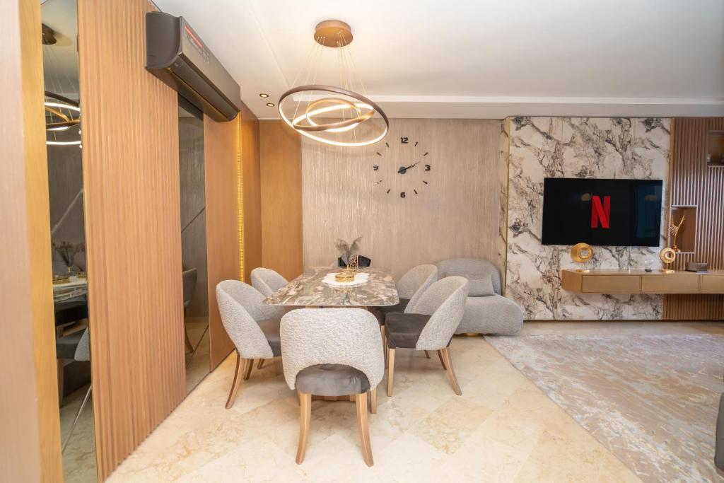 a dining room with a table and chairs and a clock at Luxury Apartment with Sea View & Free Parking in Tangier