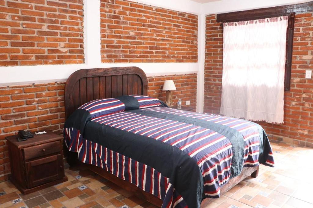 een slaapkamer met een bed in een bakstenen muur bij Hotel Campestre El Rinconcito de Chigna in Chignahuapan