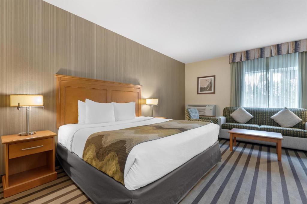 a hotel room with a bed and a couch at Best Western King George Inn & Suites in Surrey