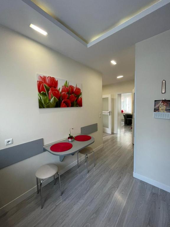 a room with two tables and a painting of red tulips at Miły zakątek in Olsztyn