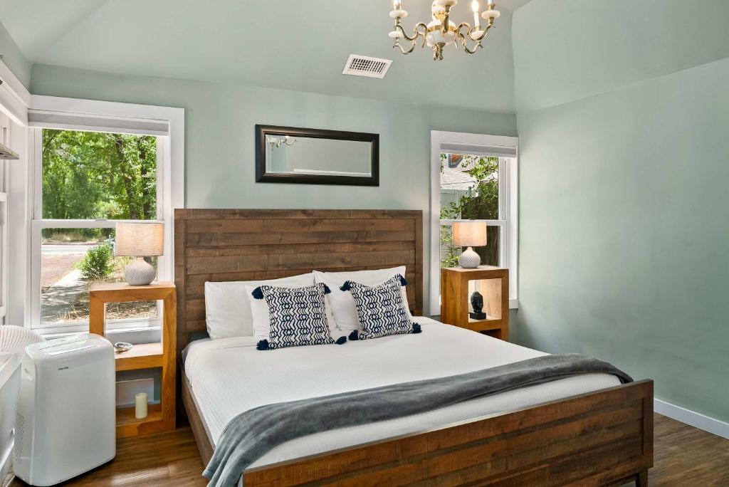 a bedroom with a large bed and two windows at Updated Downtown home next to NAU in Flagstaff
