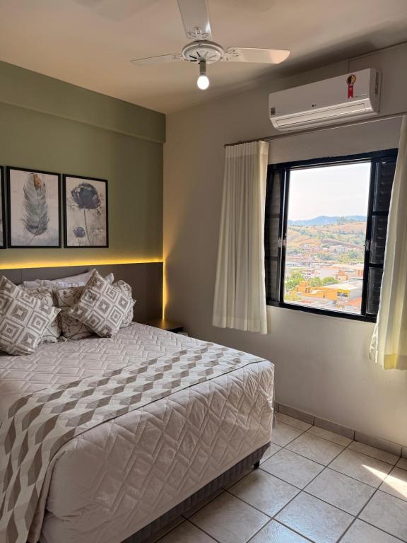 ein Schlafzimmer mit einem Bett und einem Fenster in der Unterkunft Hotel Ze Maria Cambui in Cambuí